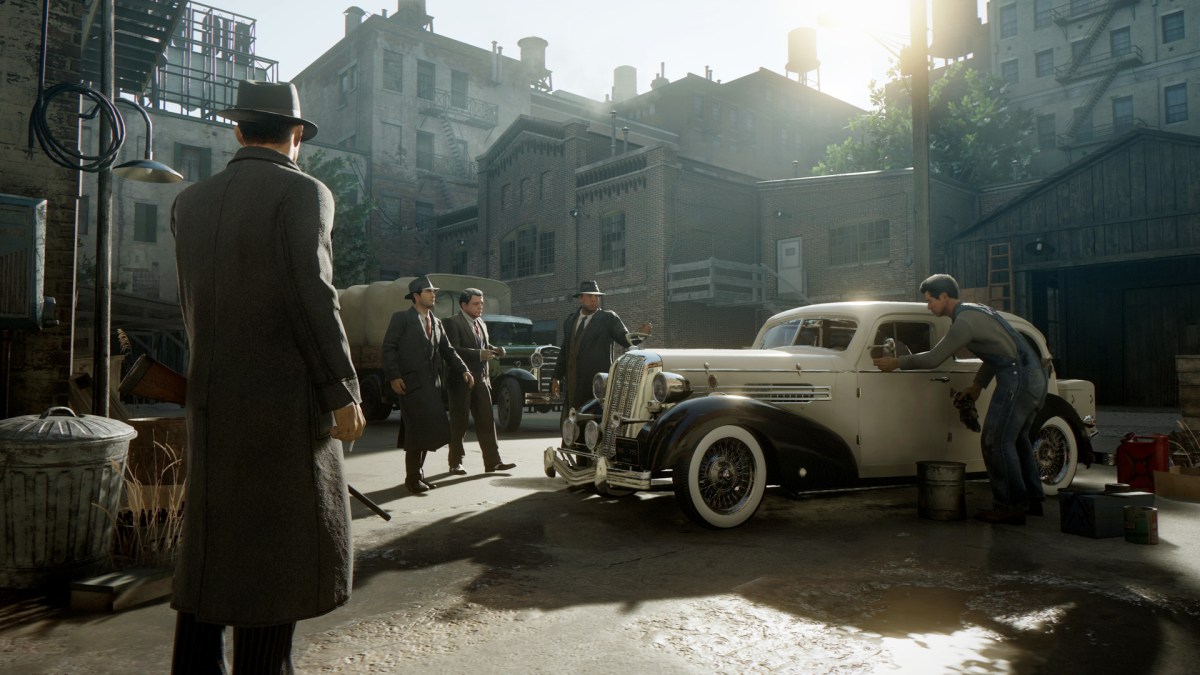A screenshot from Mafia: Definitive Edition. Mafia guys hanging around a car