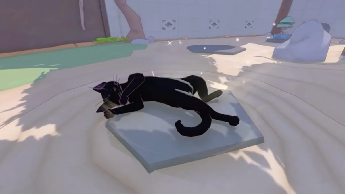 Screenshot from the official Little Kitty, Big City release date trailer. A black cat is lying on their back in a spot of shade. There are patches of sun around on the ground, and sparkles indicate the cat's happiness