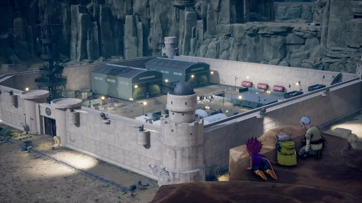 A screenshot from Sand Land, showing the first miliary base in Sand Land, surrounded by a large, gray wall. On a nearby cliff edge overlooking the base, Rao, Beelzebub, and Thief are laying in wait.