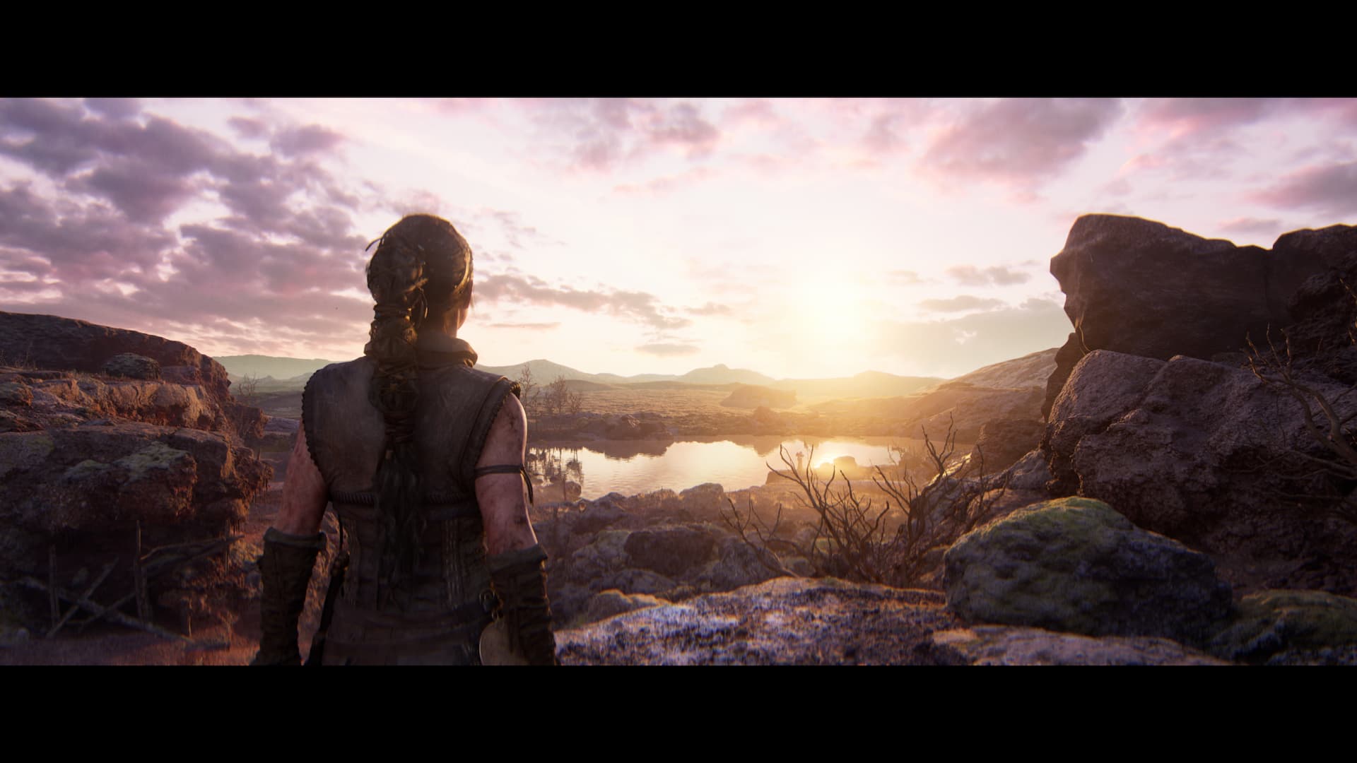 Senua looking over a picturesque landscape with a lake and a sunset