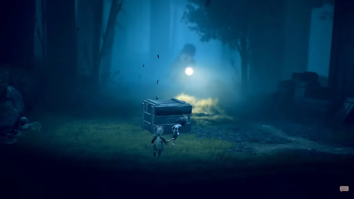 Mono and Six hide from an enemy in a graveyard in Little Nightmares II.